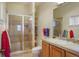 Neutral bathroom with a tiled shower, built-in shelves, and a vanity with matching tile counters at 3441 Medallion Rd, Castle Rock, CO 80104