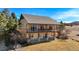 A two-story home showcasing a large, covered balcony with wooden railings and stone support columns at 3441 Medallion Rd, Castle Rock, CO 80104