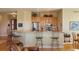 A modern kitchen featuring a breakfast bar with seating, stainless steel appliances, and light wood cabinetry at 3441 Medallion Rd, Castle Rock, CO 80104