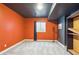 Bright basement bedroom with orange walls and large window at 5731 Boston Ct, Denver, CO 80238