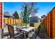 Beautiful backyard with a patio dining set, green lawn, and wooden fence providing privacy at 4452 Zenobia St, Denver, CO 80212
