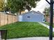 Well-maintained backyard featuring a lush lawn, privacy fence, and a neatly painted detached garage at 4452 Zenobia St, Denver, CO 80212