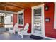Cozy front porch featuring two chairs, a hanging plant, and a decorative exterior light fixture at 4452 Zenobia St, Denver, CO 80212