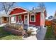 Charming red house featuring a cozy front porch with white chairs and landscaped brick garden bed at 4452 Zenobia St, Denver, CO 80212