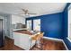 Bright kitchen with a blue accent wall, wood floors, butcher block island and modern white cabinets at 4452 Zenobia St, Denver, CO 80212