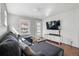 Bright living room featuring a large gray sectional, hardwood floors, and a modern entertainment center at 4452 Zenobia St, Denver, CO 80212