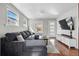Bright living room featuring a large gray sectional, hardwood floors, and a modern entertainment center at 4452 Zenobia St, Denver, CO 80212