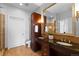 Well-appointed bathroom featuring granite countertops, dark wood cabinetry, and double sinks at 5455 Landmark Pl # 903, Greenwood Village, CO 80111