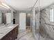 Sleek bathroom featuring a double vanity, granite counters, and a glass-enclosed shower at 13972 Hudson Way, Thornton, CO 80602