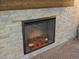 Close up of modern gas fireplace insert with decorative stacked stone surround at 13972 Hudson Way, Thornton, CO 80602