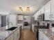 Well-equipped kitchen features white cabinets, stainless steel appliances, and an island sink at 13972 Hudson Way, Thornton, CO 80602