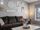 Cozy living room features a comfortable brown couch and decorative wall art at 13972 Hudson Way, Thornton, CO 80602