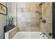 Modern bath area with a tub and shower, neutral stone tile, and glass enclosure at 315 E Bayaud Ave, Denver, CO 80209