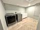 Laundry room with modern washer, dryer, and bright lighting at 18997 E Crestridge Cir, Aurora, CO 80015