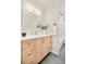 Bathroom vanity with a white countertop, light wood cabinets and a framed mirror with modern lighting at 4547 Tally Ho Trl, Boulder, CO 80301