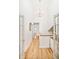 Hallway bathed in natural light through French doors, showing hardwood floors and a modern chandelier at 4547 Tally Ho Trl, Boulder, CO 80301