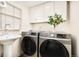 Functional laundry room with modern washer and dryer, storage cabinets, and sink at 4547 Tally Ho Trl, Boulder, CO 80301