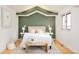 Charming bedroom featuring a green accent wall, tray ceiling, and hardwood floors at 4547 Tally Ho Trl, Boulder, CO 80301