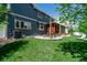 Enjoy outdoor living with a stone patio, seating, and lush green lawn in the backyard at 900 Wilshire Dr, Berthoud, CO 80513