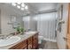 Bathroom with double sink vanity, framed mirrors, and tub with a patterned shower curtain at 900 Wilshire Dr, Berthoud, CO 80513