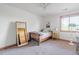Bright bedroom with a ceiling fan, a twin bed and a large mirror leaning against the wall at 900 Wilshire Dr, Berthoud, CO 80513
