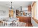 Bright dining area with hardwood floors, ample seating, and a view of the kitchen at 900 Wilshire Dr, Berthoud, CO 80513