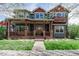 Charming two-story home featuring a spacious front porch, beautiful landscaping, and a welcoming entrance at 900 Wilshire Dr, Berthoud, CO 80513