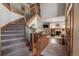 Open-concept living area with hardwood floors, staircase, fireplace, and comfortable seating at 900 Wilshire Dr, Berthoud, CO 80513