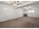 Spacious basement featuring neutral carpet, a small fireplace, and paneled walls at 11423 Steele St, Thornton, CO 80233