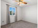 Bedroom with neutral carpet and walls, a ceiling fan, and an exterior window at 11423 Steele St, Thornton, CO 80233