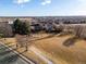 An aerial view of a community park with a playground, large open field, and sidewalks on a clear, sunny day at 11423 Steele St, Thornton, CO 80233