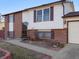 Close up of house featuring a brick facade, shutters, and well-maintained front yard at 11423 Steele St, Thornton, CO 80233