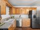 This kitchen features wood cabinets, stainless steel appliances, and wood floors at 11423 Steele St, Thornton, CO 80233