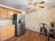 This kitchen features wood cabinets, stainless steel appliances, and wood floors at 11423 Steele St, Thornton, CO 80233