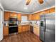 This kitchen features wood cabinets, stainless steel appliances, and wood floors at 11423 Steele St, Thornton, CO 80233