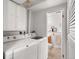 Well-lit laundry room with a washer and dryer adjacent to a half-bath at 11423 Steele St, Thornton, CO 80233