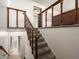 Bright foyer showcasing a carpeted staircase with wooden railing and white brick accent wall at 11423 Steele St, Thornton, CO 80233