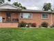 Brick house with a landscaped front yard, showcasing a charming entrance at 3515 Pierce St, Wheat Ridge, CO 80033