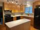 Spacious kitchen featuring light wood cabinets, an island, and modern appliances at 3515 Pierce St, Wheat Ridge, CO 80033