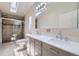 Bathroom features a double sink vanity with marble counters and an updated shower at 253 Cherokee Pl, Brighton, CO 80603