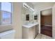 Updated bathroom features a double sink vanity with marble counters and updated lighting at 253 Cherokee Pl, Brighton, CO 80603