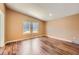 An empty bedroom offers natural light and gorgeous hardwood floors at 253 Cherokee Pl, Brighton, CO 80603
