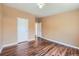 Bright bedroom features hardwood floors, tan colored walls, and a white door at 253 Cherokee Pl, Brighton, CO 80603