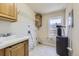 Functional laundry room with a utility sink, overhead storage, and a window at 253 Cherokee Pl, Brighton, CO 80603