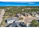 Aerial view of homes with well-maintained yards, trees and landscaping in a mountain community at 1798 Summerglow Ln, Monument, CO 80132
