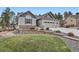 Beautiful home featuring stone accents, manicured lawn, and a three-car garage at 1798 Summerglow Ln, Monument, CO 80132