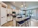 Modern kitchen featuring white cabinets, granite countertops, stainless steel appliances, and a cozy breakfast bar with blue stools at 1798 Summerglow Ln, Monument, CO 80132