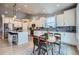 Open kitchen with white cabinets, stainless steel appliances, granite countertops, and an adjacent dining area with a wooden table at 1798 Summerglow Ln, Monument, CO 80132