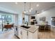Bright kitchen with a granite island, black sink, and an open floor plan that connects to the living room and dining area at 1798 Summerglow Ln, Monument, CO 80132