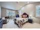 Bright main bedroom with vaulted ceilings, plush carpet, large windows, and a luxurious floral-patterned bed at 1798 Summerglow Ln, Monument, CO 80132